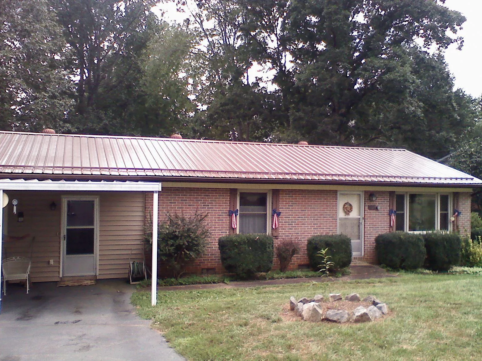 Bronze metal roof and carport on a brick ranch home — Roof Repair work by our crew in Evansville